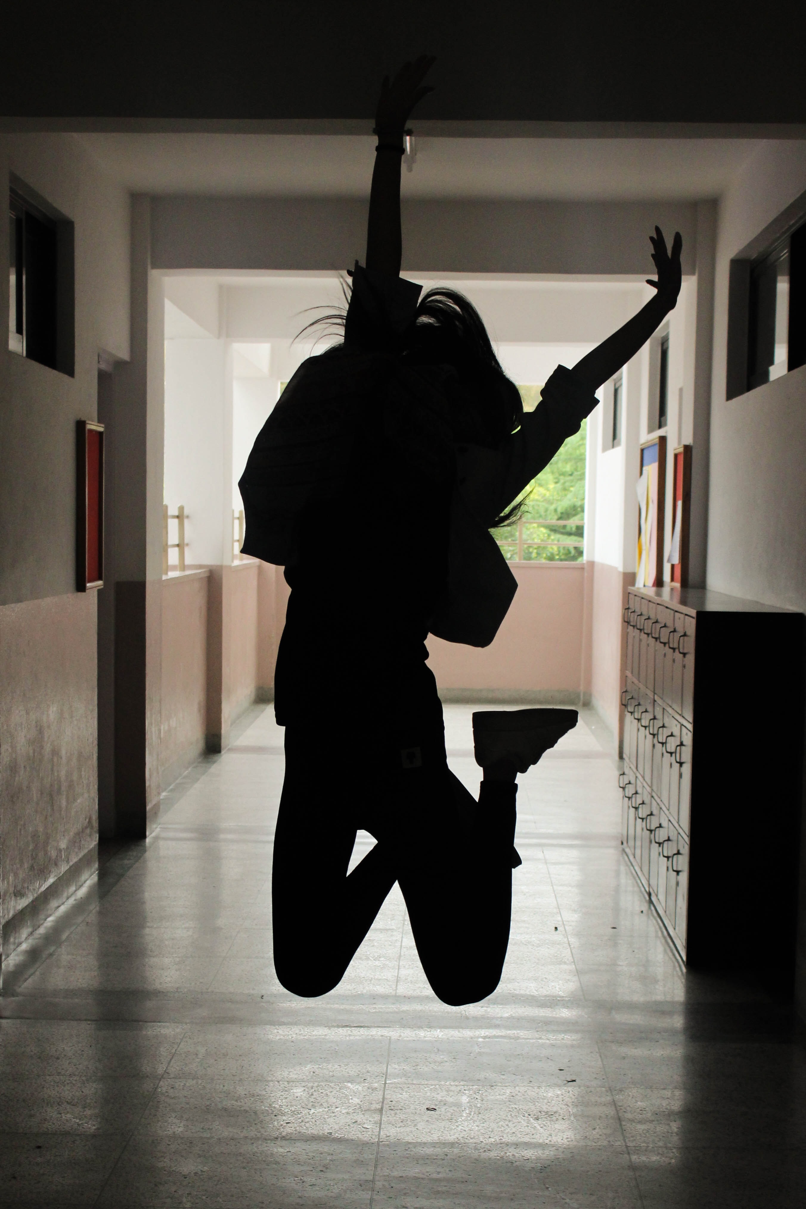 ombre d'une jeune fille qui saute dans un couloir vide d'école